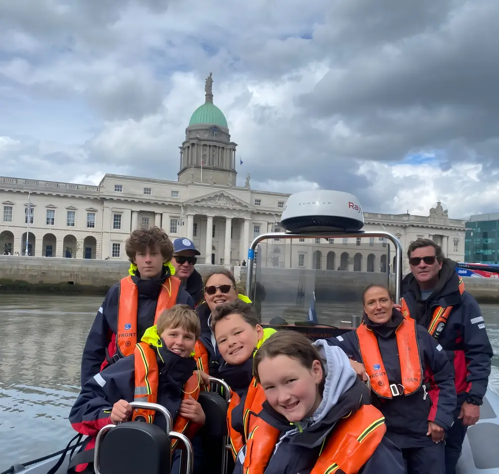 A scenic view of a boat tour on the water with people enjoying the ride, representing the story of Dublin Boat Tour
