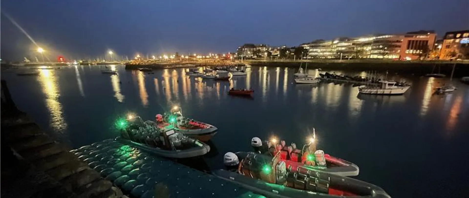 Passengers enjoying a scenic boat tour on the river with Dublin cityscape in the background