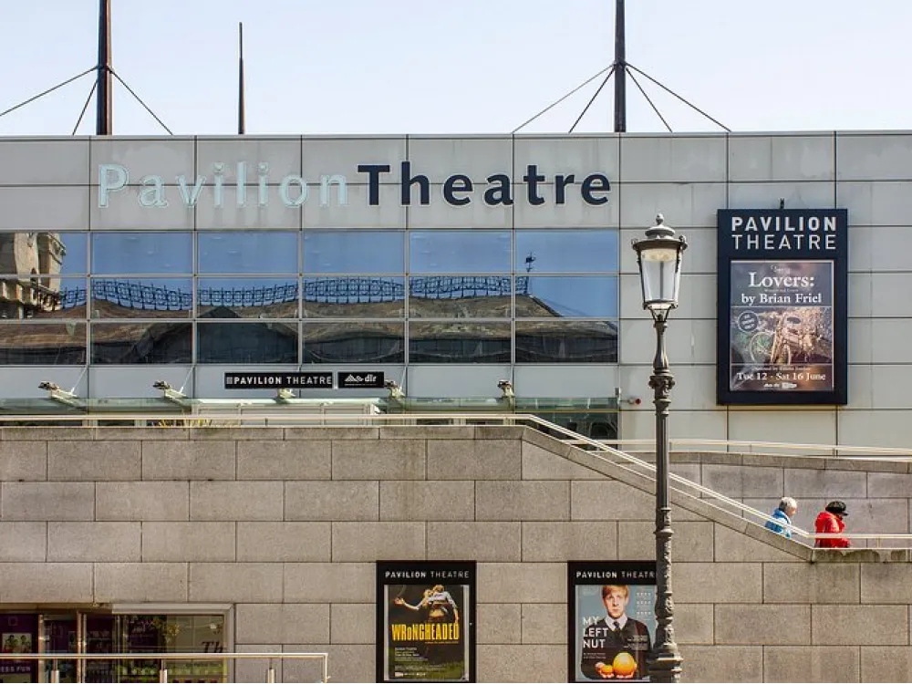 Exterior of Pavilion Theatre with glass façade, show posters, and signage in an urban setting